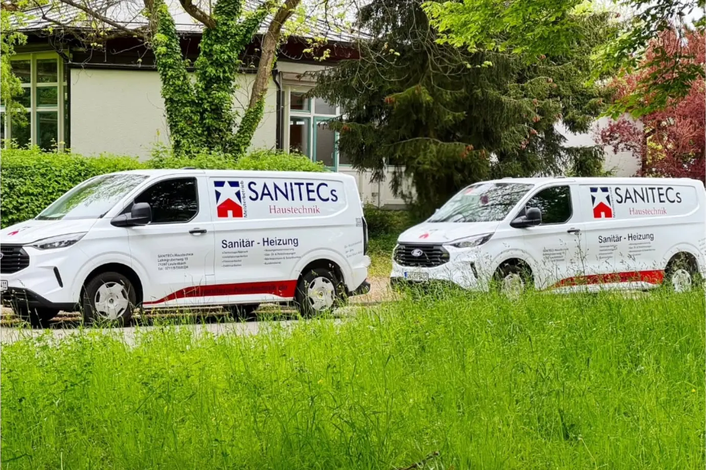 Zwei beschriftete SANITECs-Einsatzwagen vor dem Betrieb — Sanitär und Heizung, Meisterbetrieb Winnenden